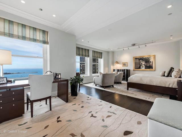 bedroom with a water view, crown molding, multiple windows, and light hardwood / wood-style flooring