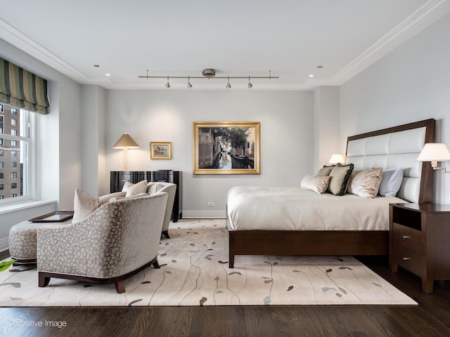 bedroom with crown molding, track lighting, and wood-type flooring