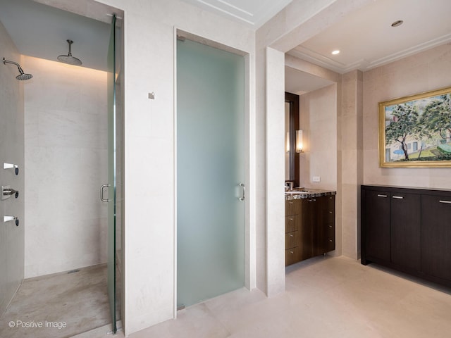 bathroom featuring vanity, tile walls, and a shower with door