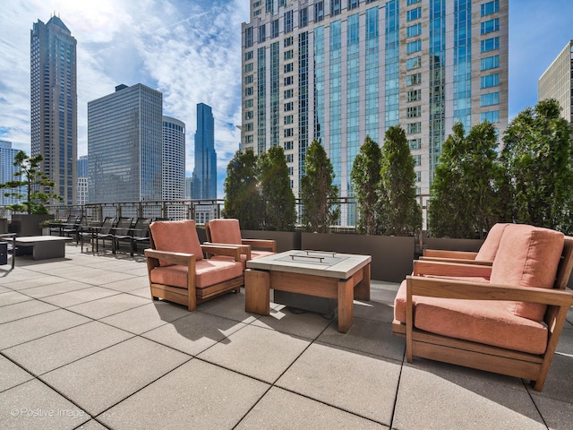 view of patio with an outdoor living space with a fire pit