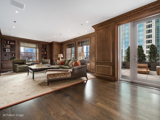 living room with a healthy amount of sunlight, built in features, and dark hardwood / wood-style flooring