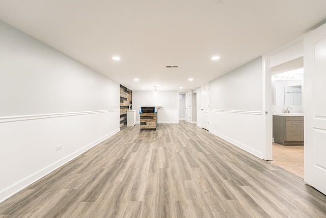 unfurnished living room with light hardwood / wood-style floors and sink