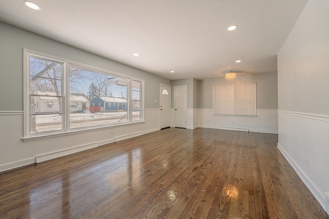 unfurnished living room with dark wood-type flooring and an inviting chandelier