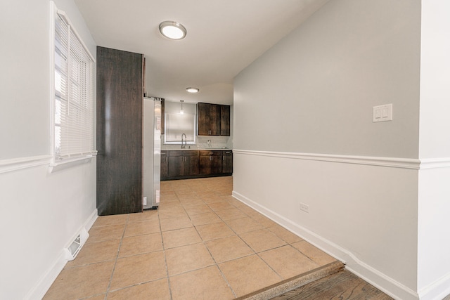 corridor with sink and light tile patterned floors