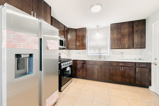 kitchen with pendant lighting, dark brown cabinets, sink, and stainless steel appliances