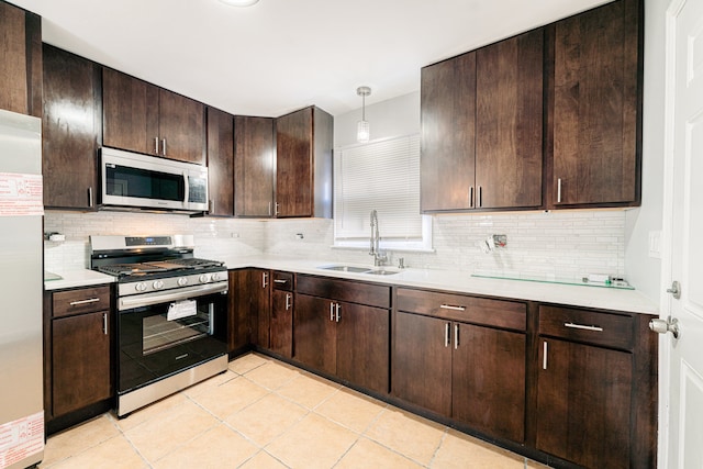 kitchen featuring backsplash, sink, decorative light fixtures, appliances with stainless steel finishes, and dark brown cabinets