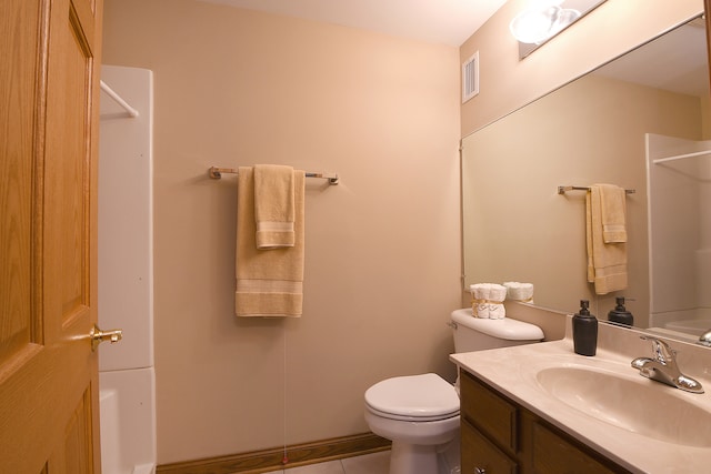 bathroom with toilet, tile floors, and vanity with extensive cabinet space