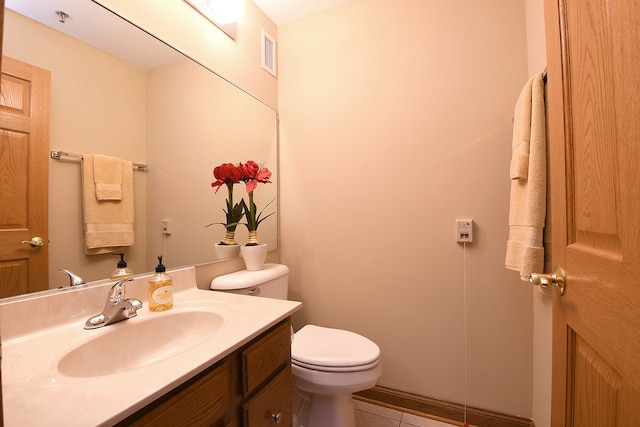 bathroom with toilet, tile floors, and vanity with extensive cabinet space