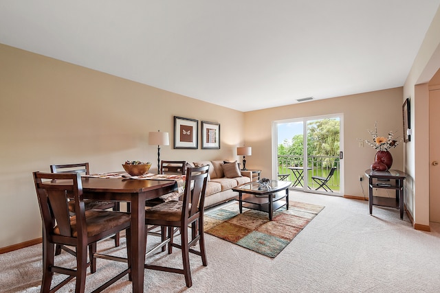 dining area featuring light carpet