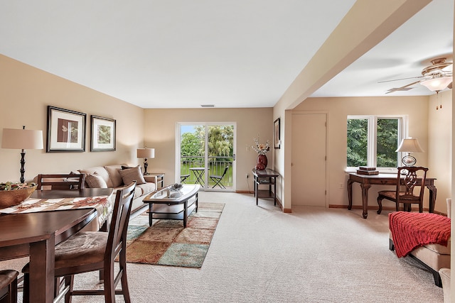 carpeted living room with ceiling fan