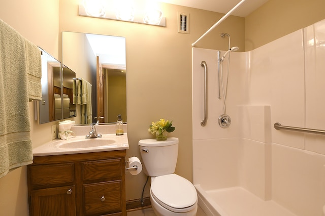 bathroom featuring vanity, a shower, and toilet