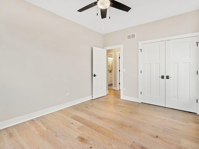 unfurnished bedroom with ceiling fan, a closet, and light wood-type flooring