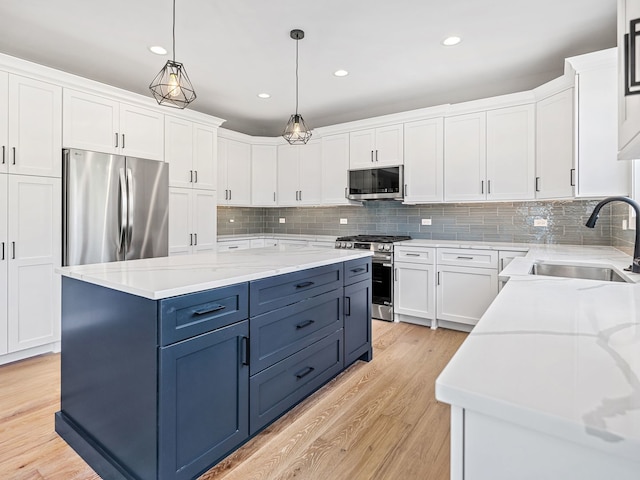 kitchen with white cabinets, stainless steel appliances, and hanging light fixtures