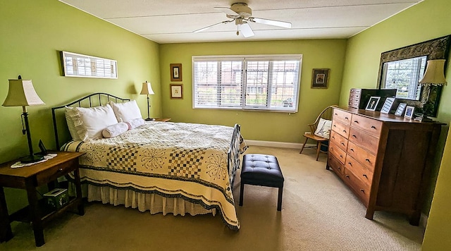 bedroom featuring a ceiling fan, light colored carpet, and baseboards