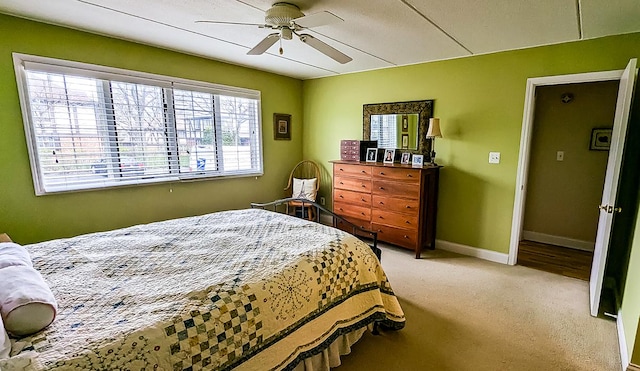 bedroom with ceiling fan, light colored carpet, and baseboards