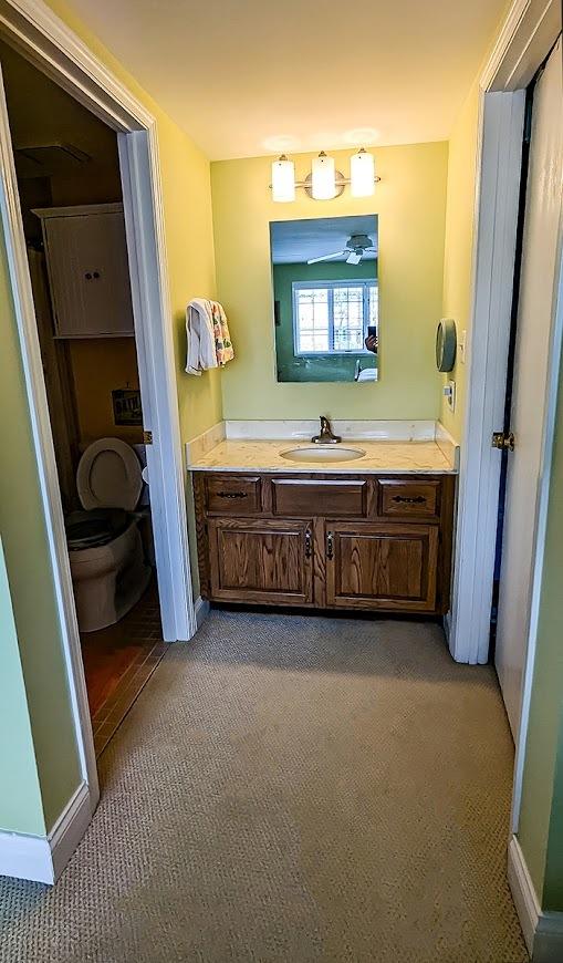 bathroom with baseboards, toilet, and vanity