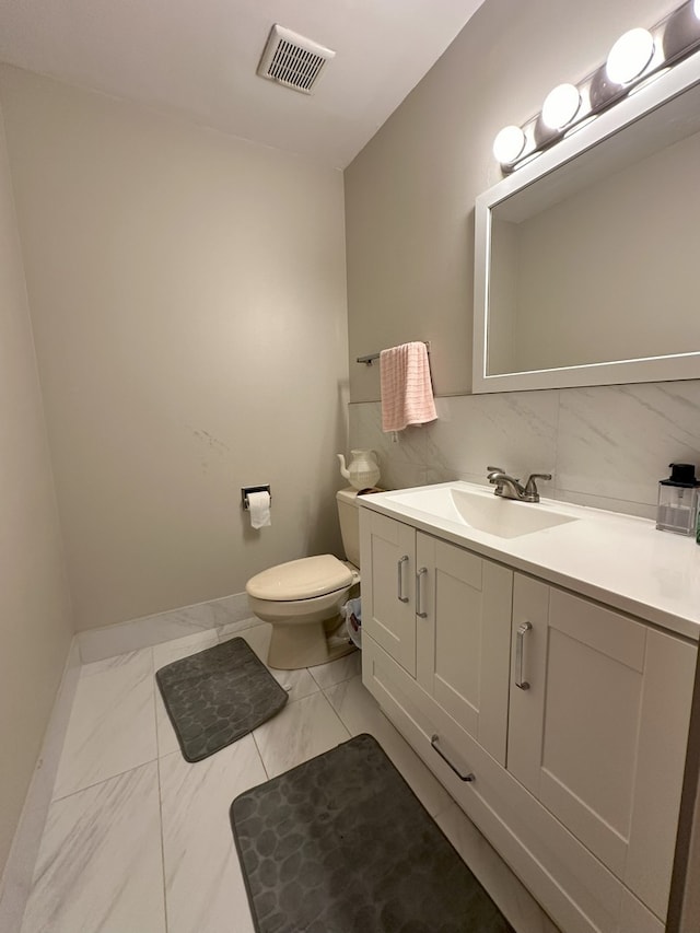 bathroom featuring toilet, tasteful backsplash, tile floors, and vanity