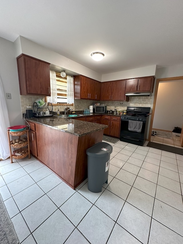 kitchen with dark stone countertops, light tile floors, sink, kitchen peninsula, and black range with gas cooktop