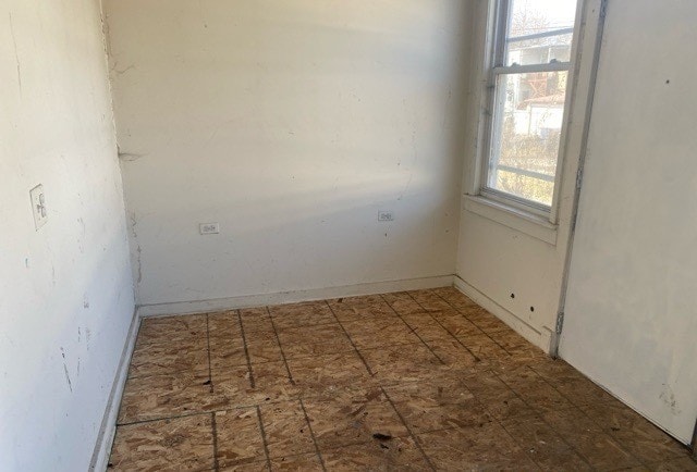 unfurnished room featuring dark tile flooring