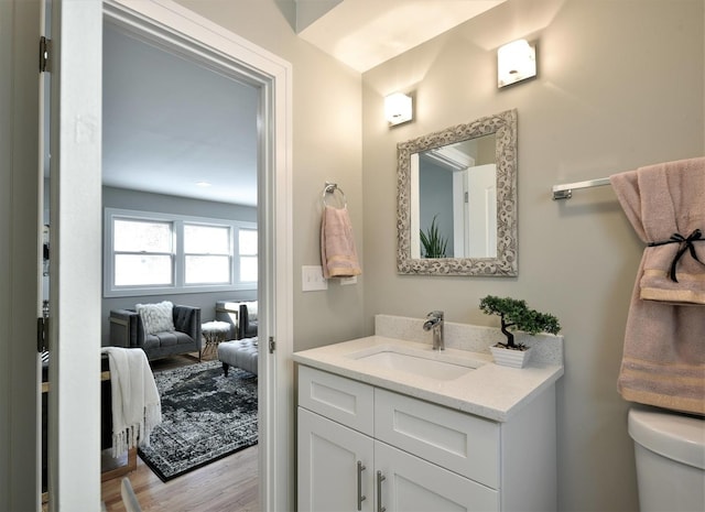 bathroom featuring hardwood / wood-style flooring, toilet, and vanity