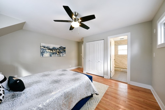 bedroom featuring connected bathroom, multiple windows, light hardwood / wood-style floors, and ceiling fan