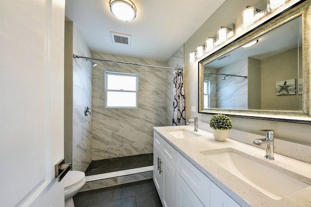 bathroom featuring toilet, tile floors, dual vanity, and a shower with shower curtain