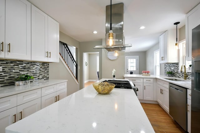 kitchen with sink, pendant lighting, island exhaust hood, and dishwasher