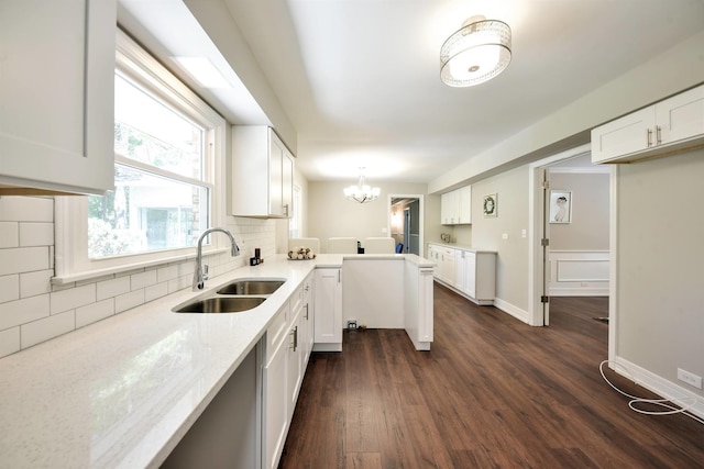 kitchen featuring backsplash, a notable chandelier, sink, white cabinets, and dark hardwood / wood-style flooring