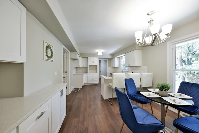 dining room with dark hardwood / wood-style flooring and a notable chandelier