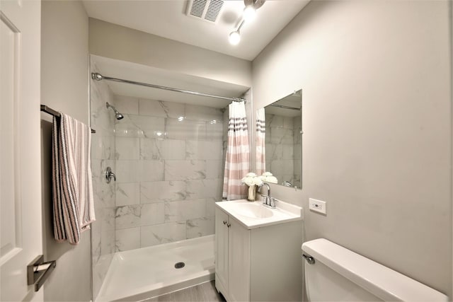 bathroom with large vanity, a shower with shower curtain, and toilet