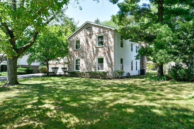 view of front of house with a front yard and central AC