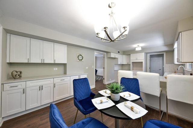 dining space featuring a chandelier, dark wood-type flooring, and sink