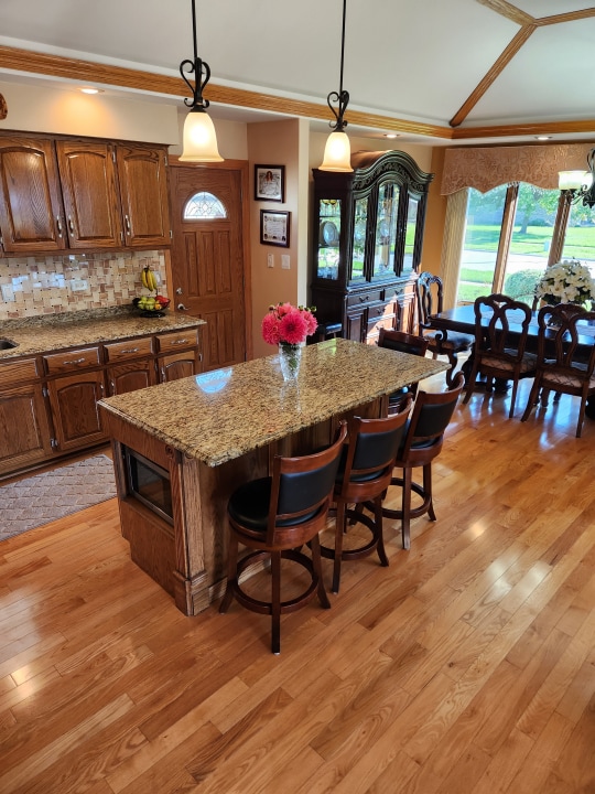 kitchen with a kitchen island, light hardwood / wood-style flooring, a kitchen breakfast bar, and pendant lighting