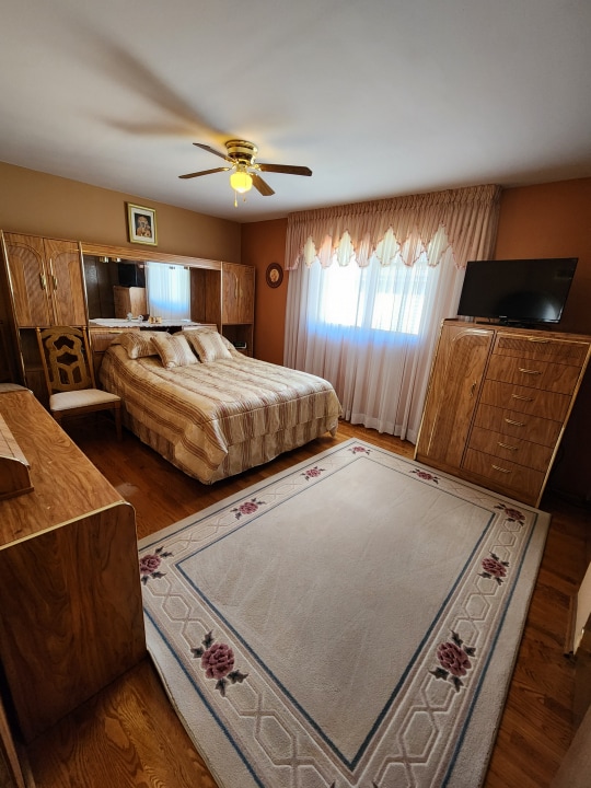 bedroom with ceiling fan and dark wood-type flooring