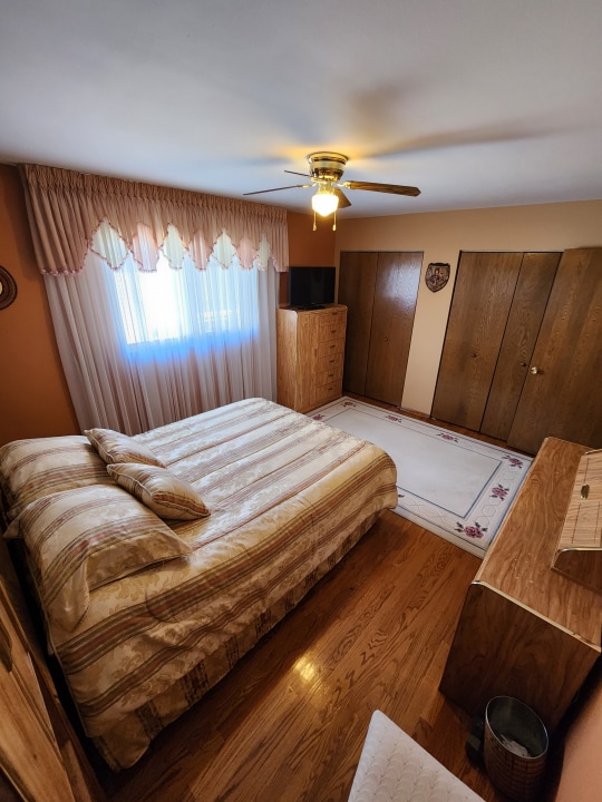 bedroom featuring ceiling fan and dark hardwood / wood-style floors