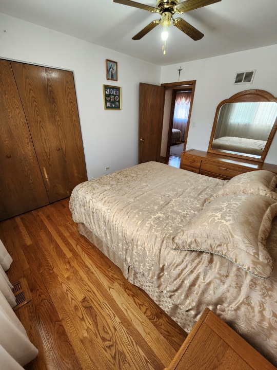 bedroom with ceiling fan and hardwood / wood-style flooring