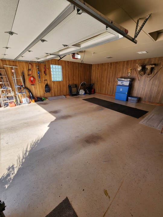 garage with wood walls and a garage door opener