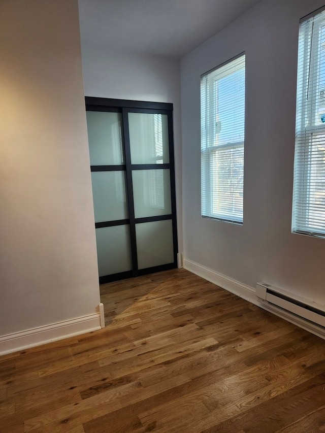 empty room with dark wood-type flooring and a wealth of natural light