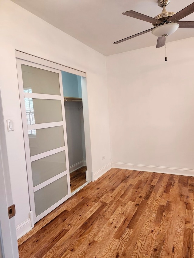 unfurnished bedroom featuring a closet, light hardwood / wood-style floors, and ceiling fan