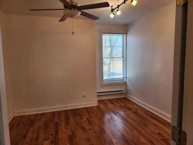 spare room with track lighting, ceiling fan, baseboard heating, and dark hardwood / wood-style flooring