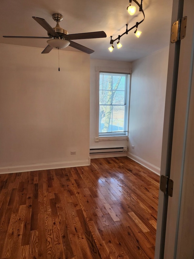 spare room with ceiling fan, track lighting, a baseboard radiator, and dark wood-type flooring