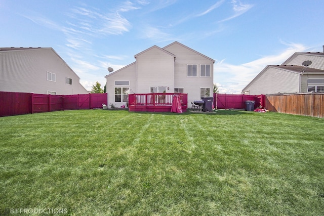 back of property with a yard and a wooden deck