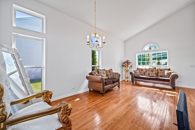 living room featuring a notable chandelier, hardwood / wood-style floors, a healthy amount of sunlight, and high vaulted ceiling