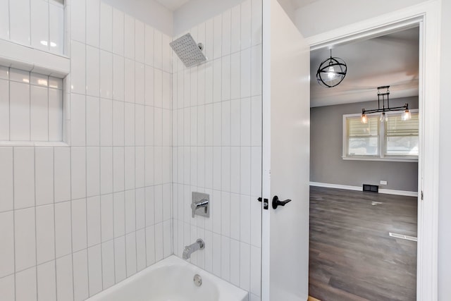 bathroom with tiled shower / bath and wood-type flooring