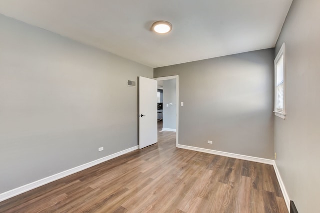 spare room with wood-type flooring