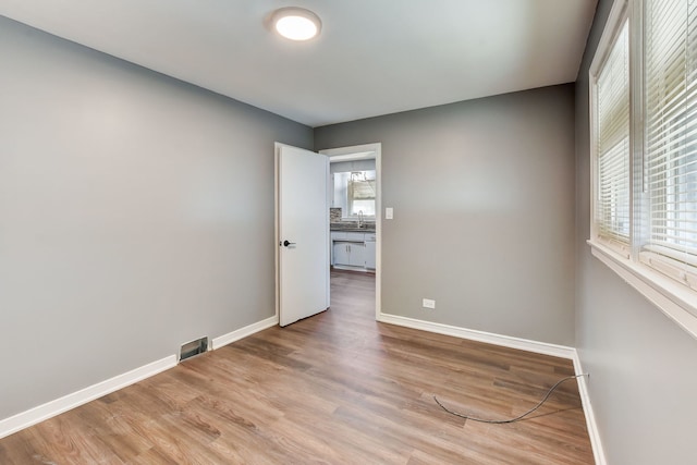 spare room featuring sink and light wood-type flooring