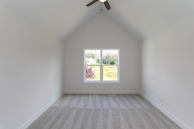 carpeted empty room featuring vaulted ceiling and ceiling fan