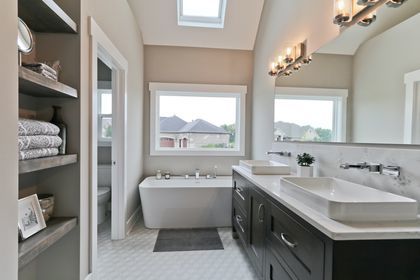 bathroom featuring backsplash, vanity, lofted ceiling, a bath, and toilet