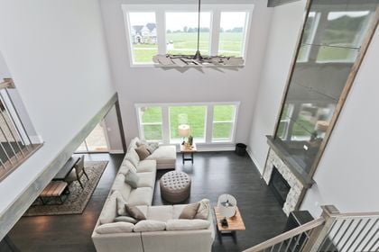 living room featuring dark hardwood / wood-style floors, a healthy amount of sunlight, a stone fireplace, and an inviting chandelier