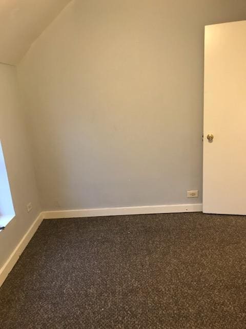 spare room featuring lofted ceiling and carpet floors